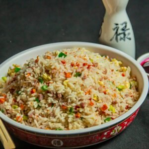 A vibrant bowl of Asian-style fried rice served with traditional condiments for a mouthwatering experience.